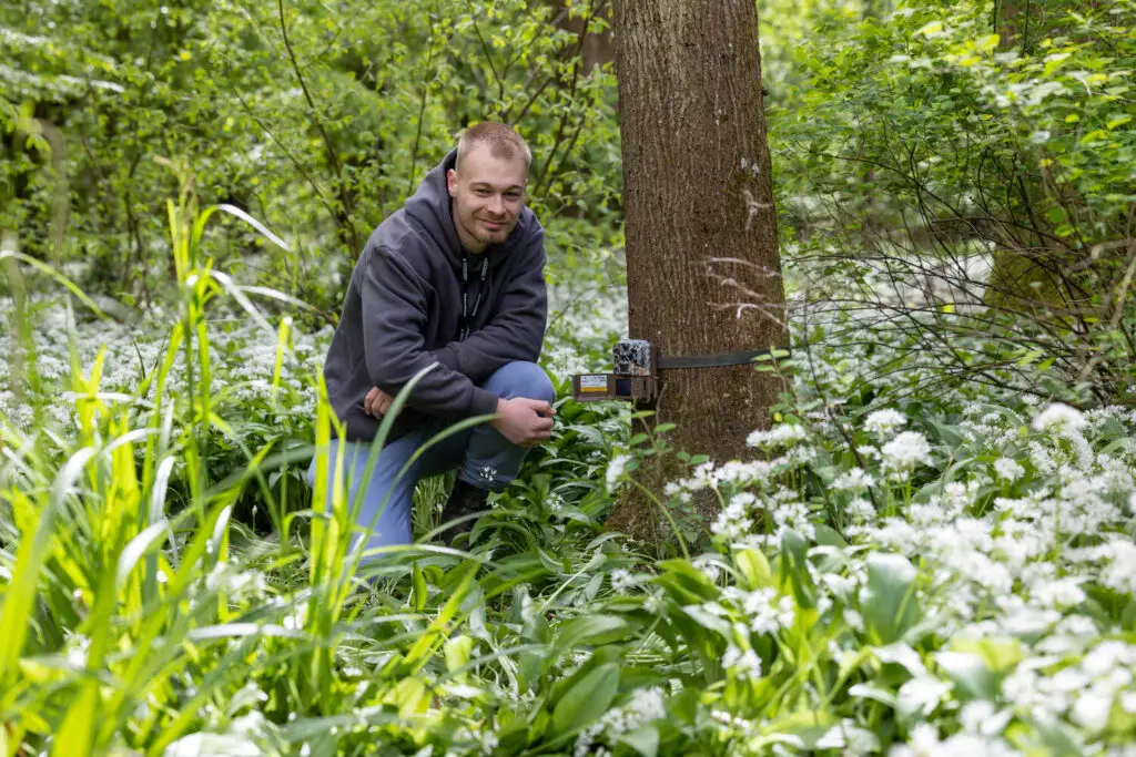 a countryside student posing my a tree with wild plants