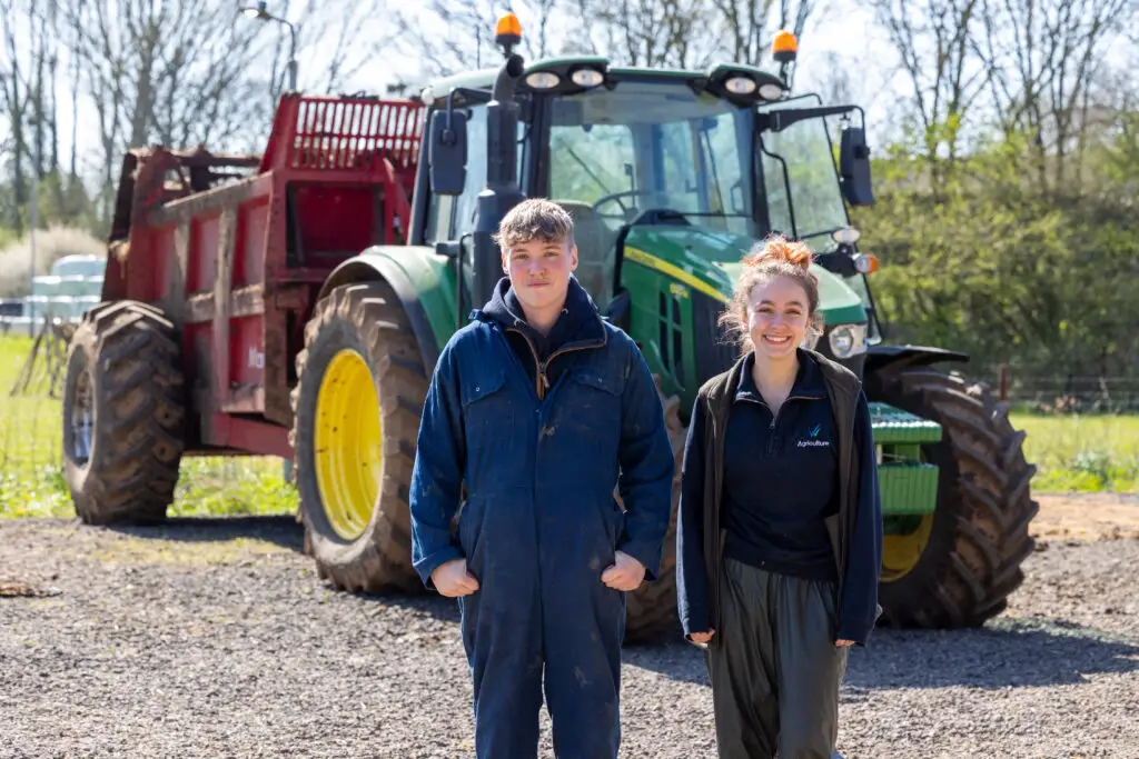 Students standing in front of tractor
