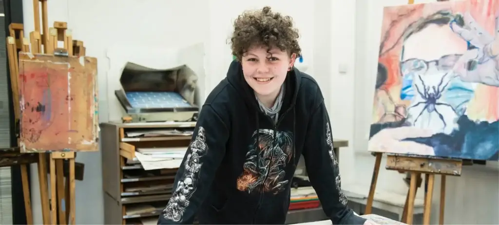 Student stood in front of their easel