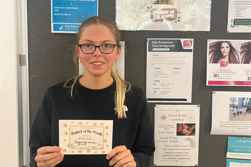 Female college student, holding a certificate that reads 'Student of the Month'.