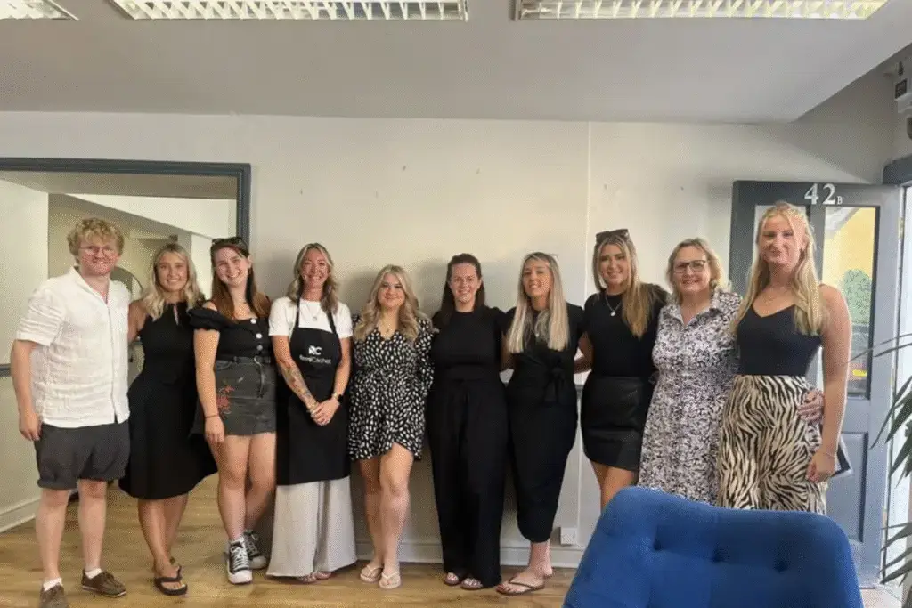 A group of people smiling together inside a busy salon.