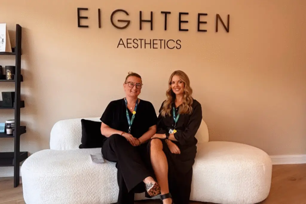 Two people seated on a sofa inside Eighteen Aesthetics clinic