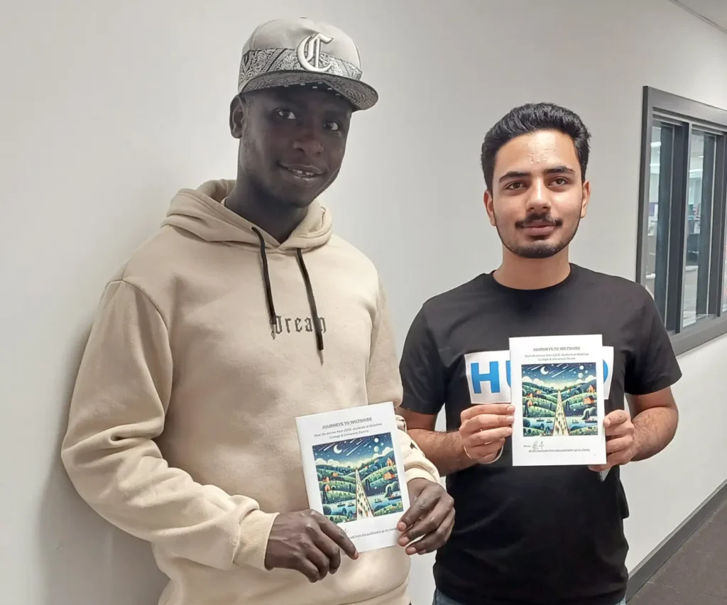 Two ESOL students holding copies of Journeys To Wiltshire in a College corridor.