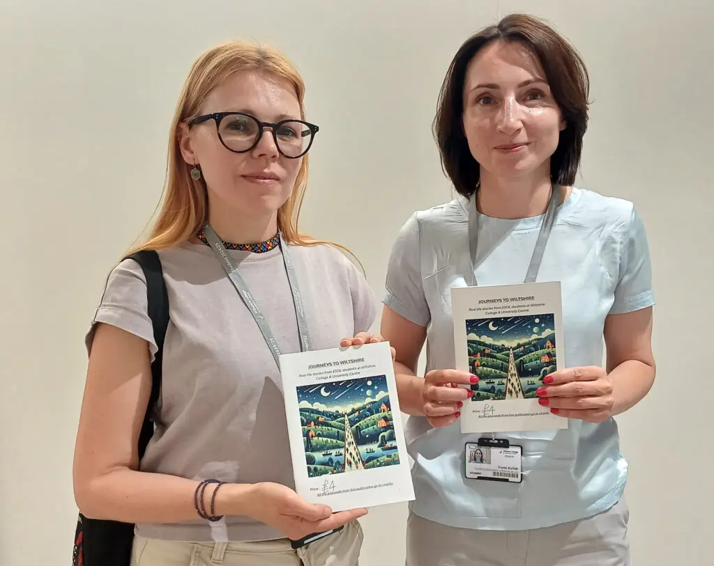 Two ESOL students holding copies of Journeys To Wiltshire.