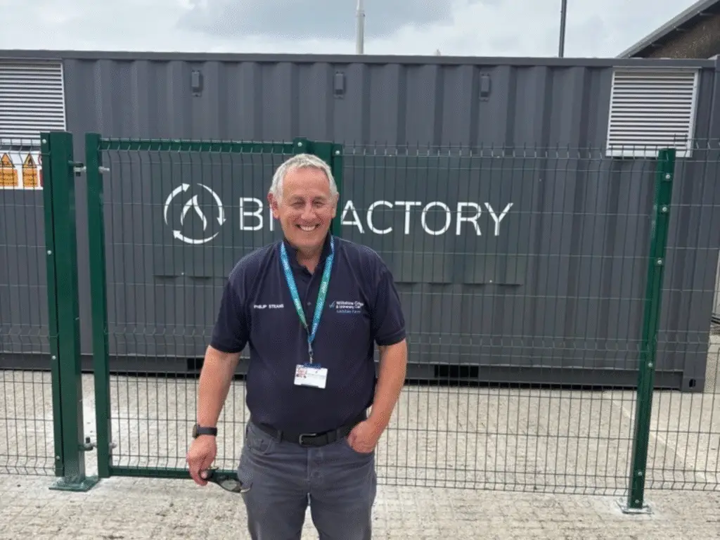Phil, Farm and Estate Manager at Wiltshire College & University Centre Lackham, smiling while standing in front of the AD (Anaerobic Digester) plant.