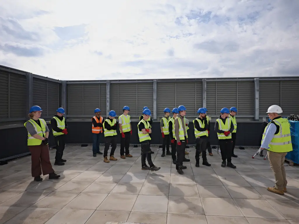 Construction students in safety gear gather on the roof area of the Trowbridge Integrated Care Centre site for a guided talk.