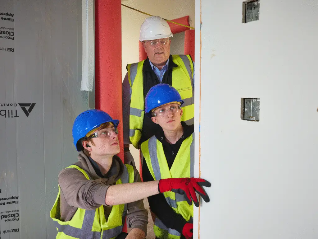 Construction students observe wall fittings and finishes inside the new Trowbridge Integrated Care Centre under the guidance of a Tilbury Douglas supervisor.