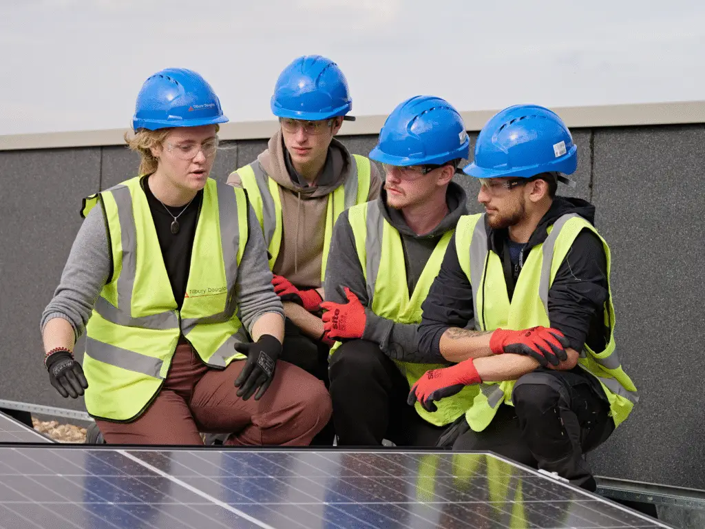Construction students examine rooftop solar panels at the new Trowbridge Integrated Care Centre alongside a Tilbury Douglas representative.