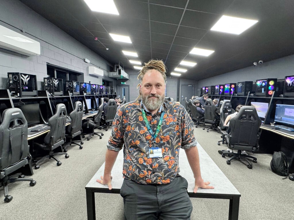 Lecturer standing in the expanded modern digital suite at Tech Trowbridge, with students working at high-spec computers for Games Development and eSports courses.