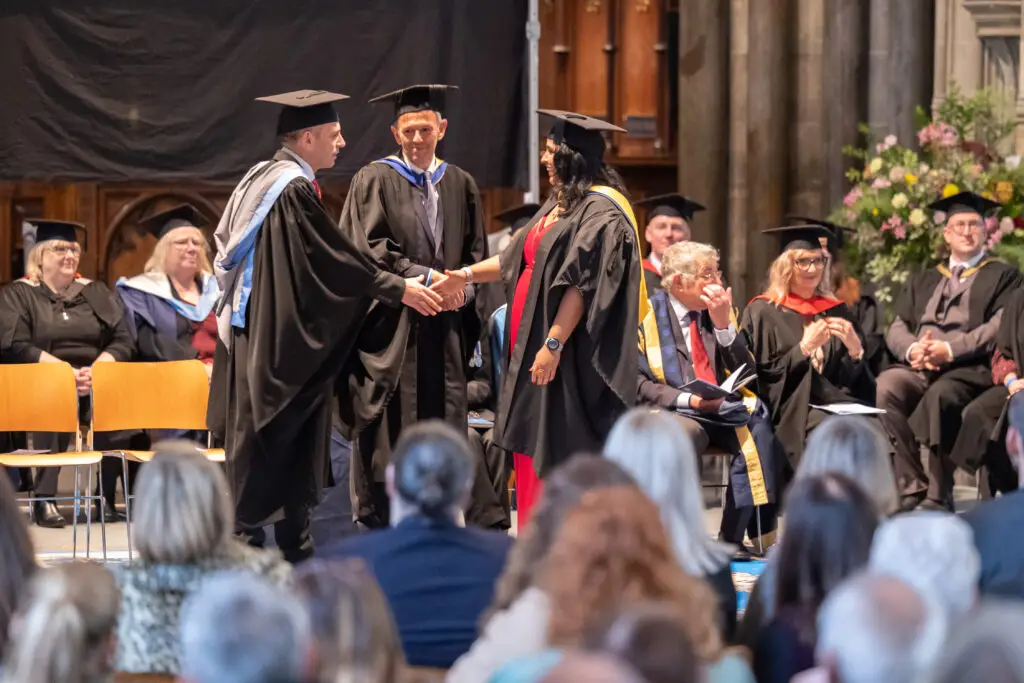 A graduate shaking hands with Wiltshire College principal Iain Hatt.