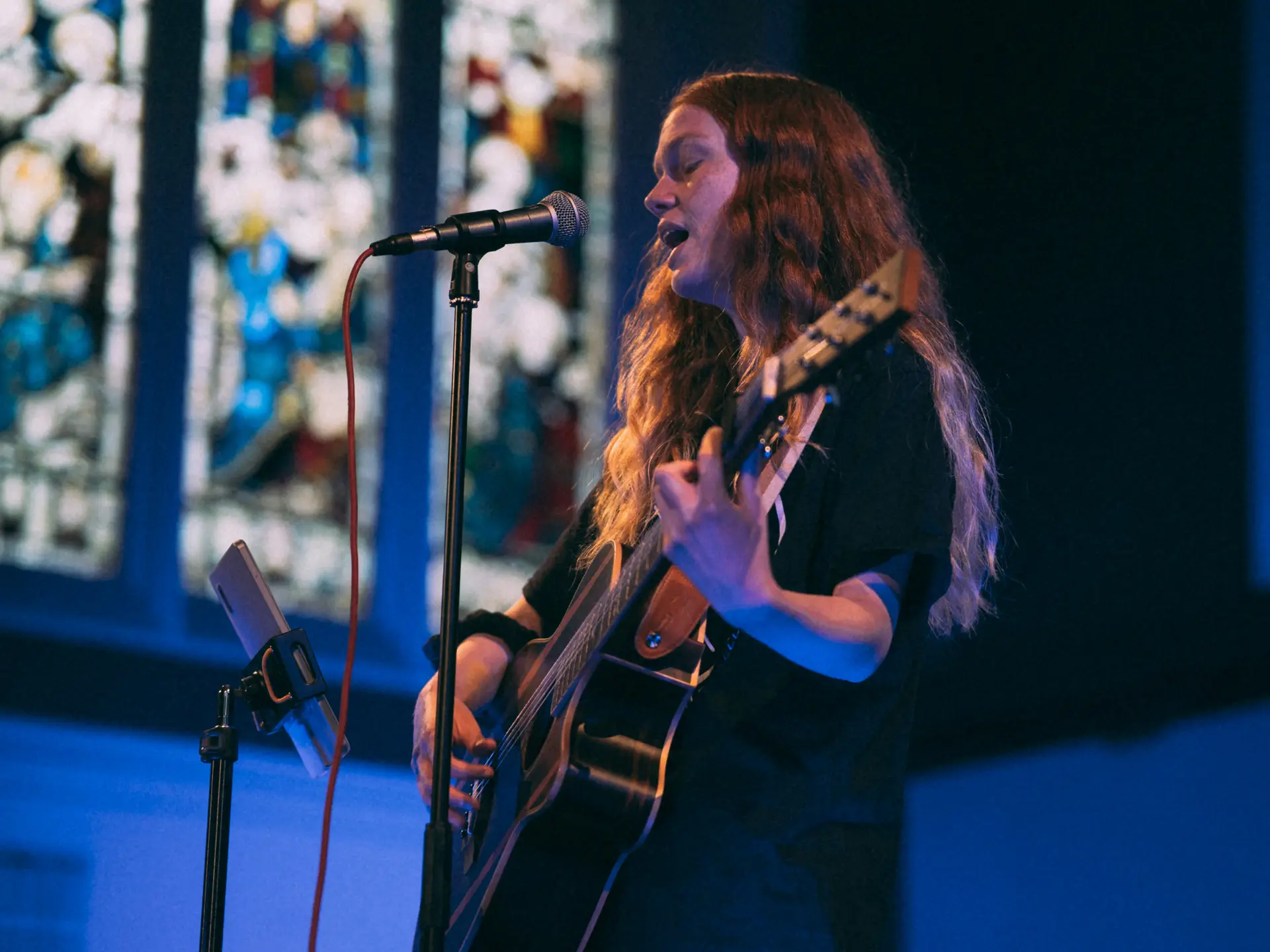 Student holding a guitar and singing