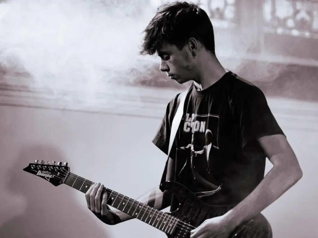 black and white photo of a student playing guitar