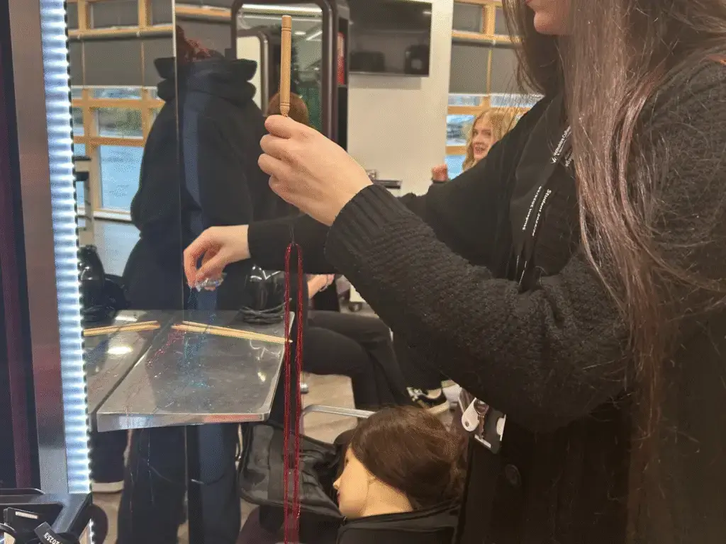 A Hair and Beauty student preparing hair tinsel during a festive salon treatment.