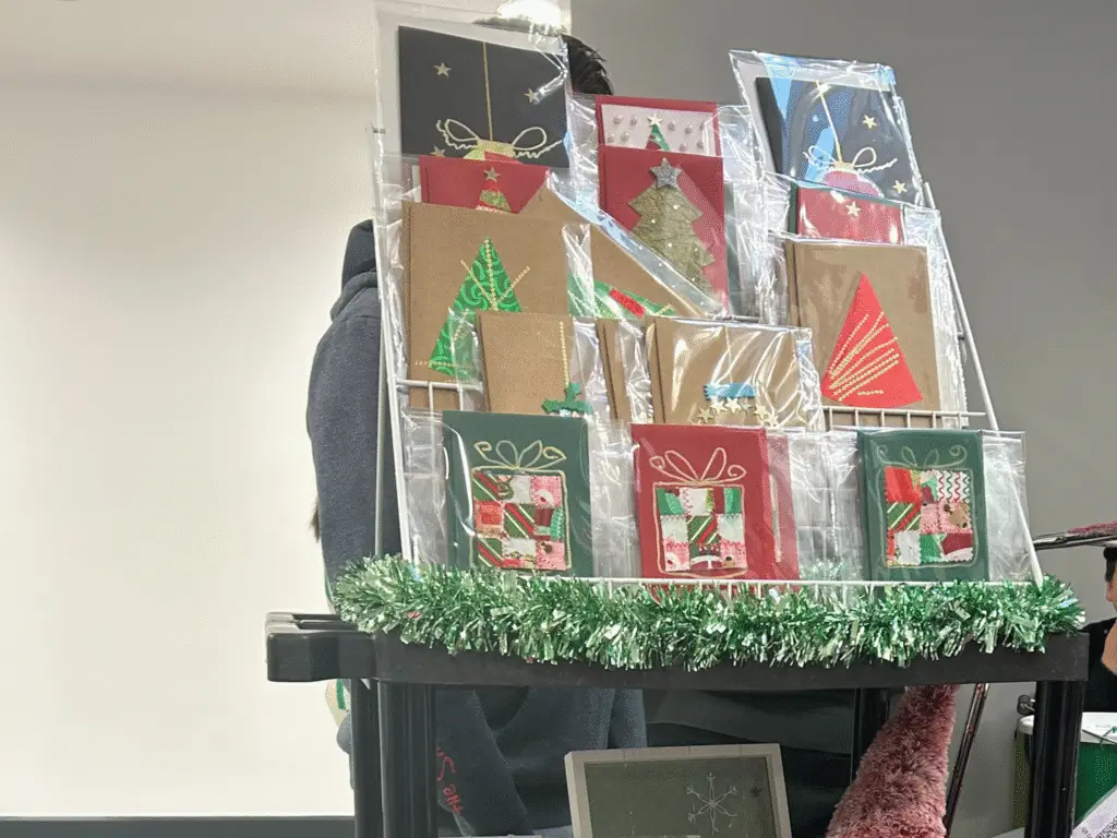 A display stand holding handmade Christmas cards decorated with festive designs.