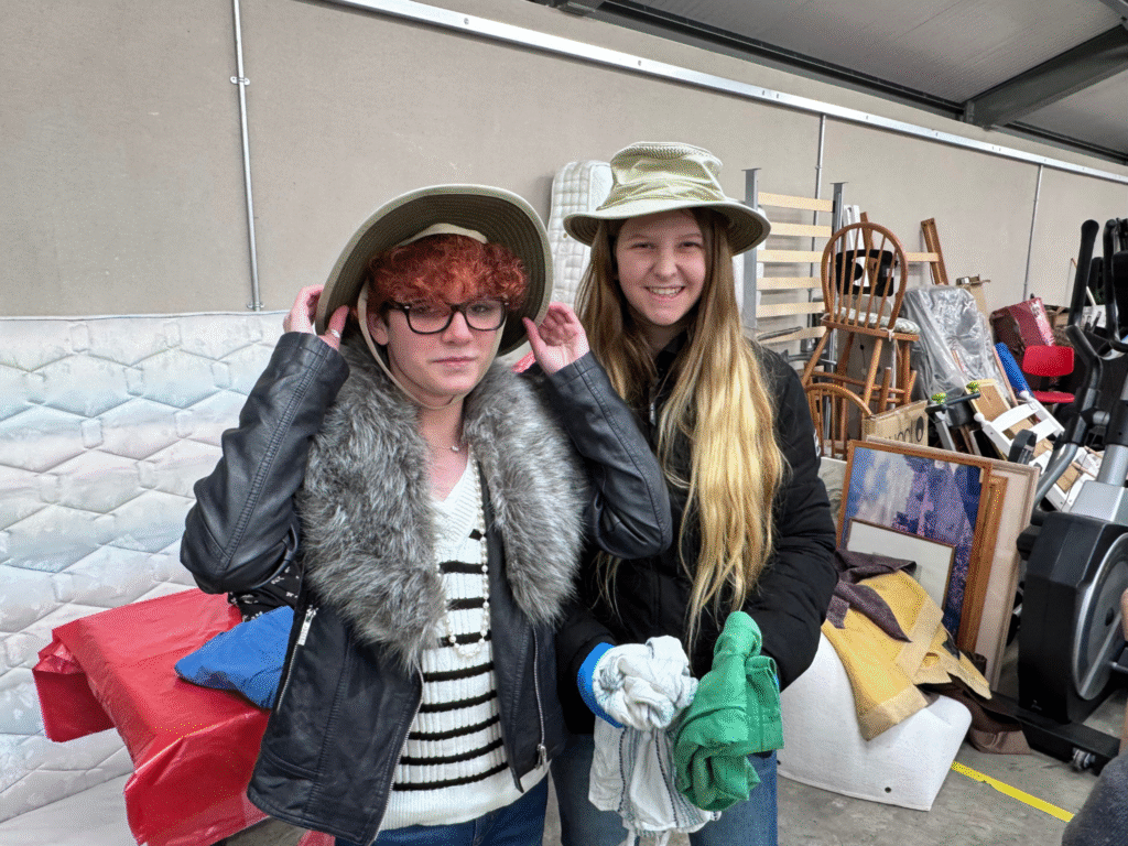 Two Wiltshire College & University Centre students examine donated clothing during a visit to Dorothy House’s warehouse.