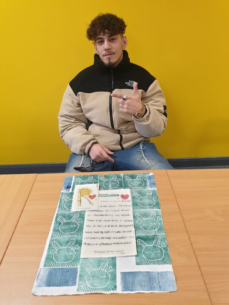 ESOL student proudly showing art work created for Salisbury museum