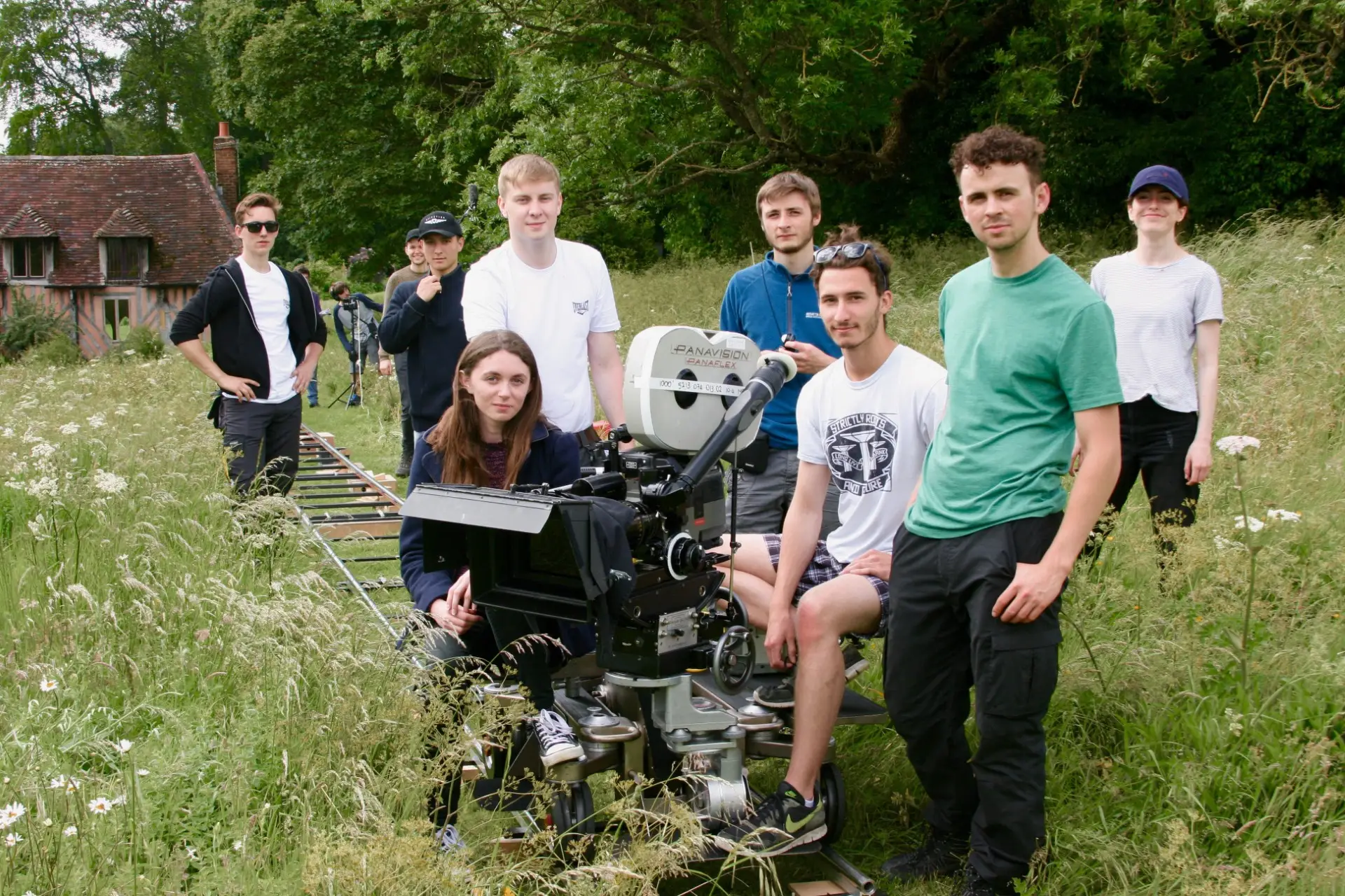 Students outside around a big camera.