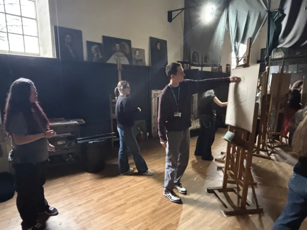 A tutor offering feedback to students during a life drawing class at Sarum Studio, supporting the development of traditional observational drawing techniques.