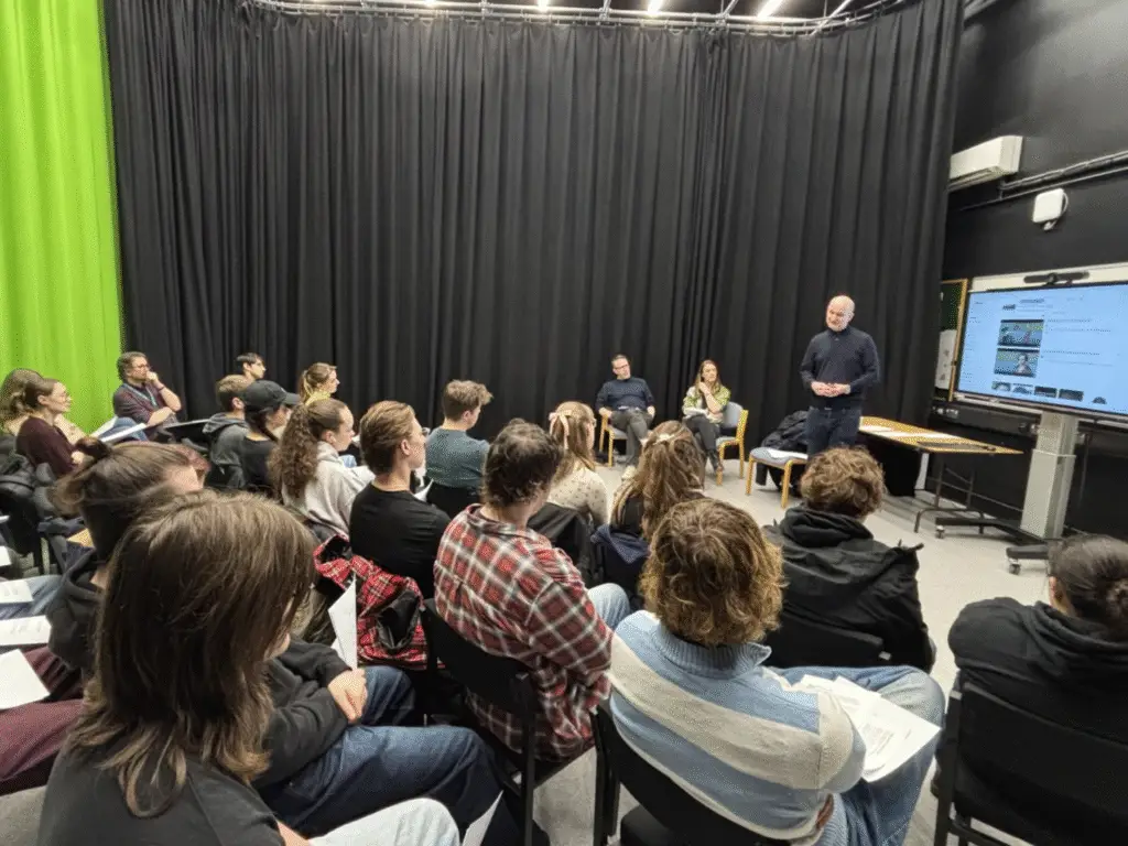 Film and TV students seated in a studio space as a guest director leads a workshop discussion at Wiltshire College & University Centre.