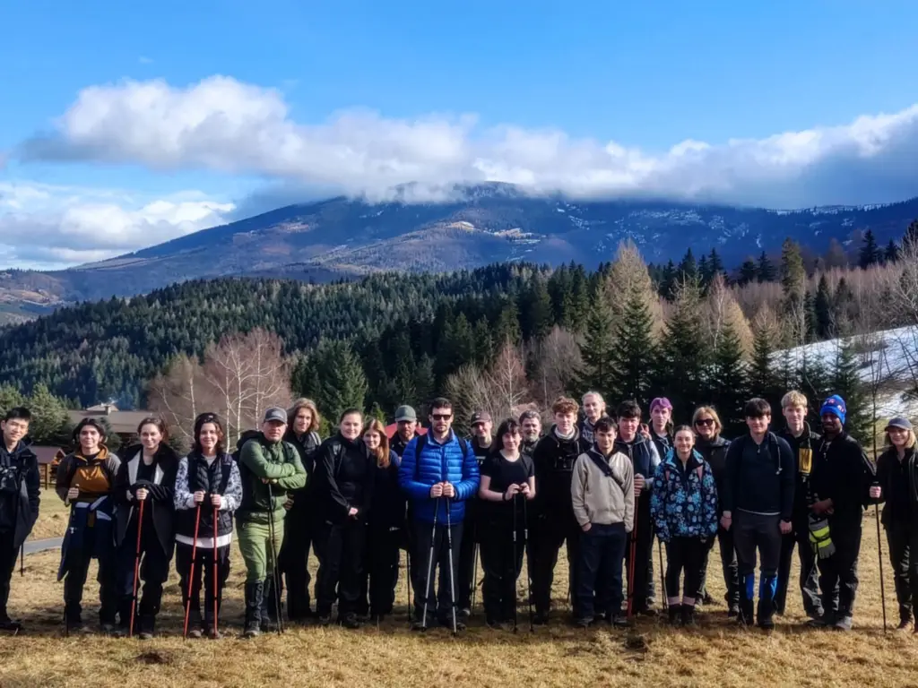 Group of students and staff standing with a backdrop of Polish mountains