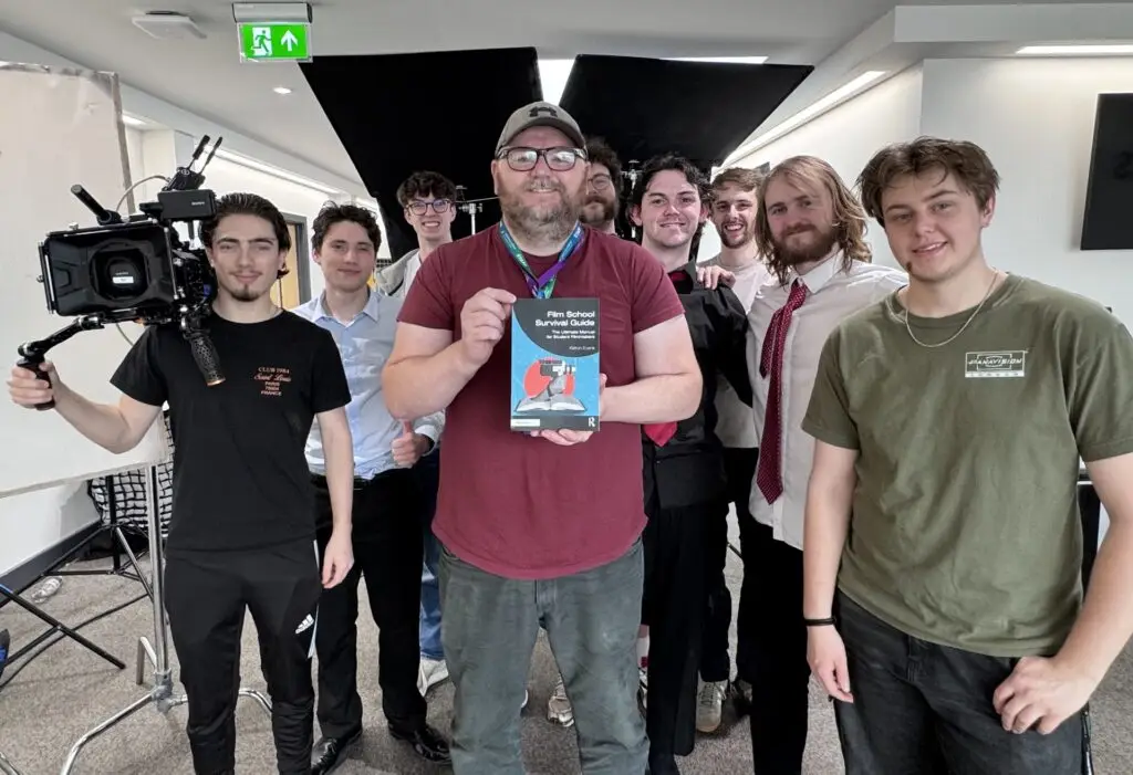 Lecturer with his new book and his students