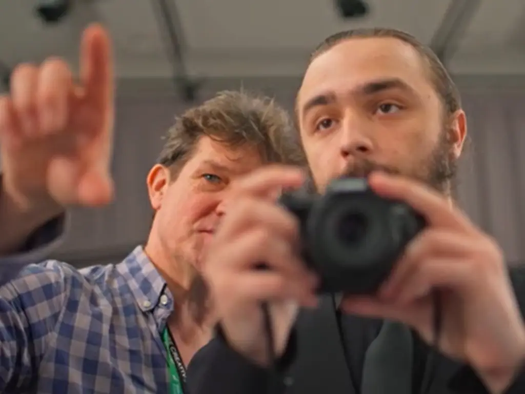 Lecturer helping a teacher with his camera skills