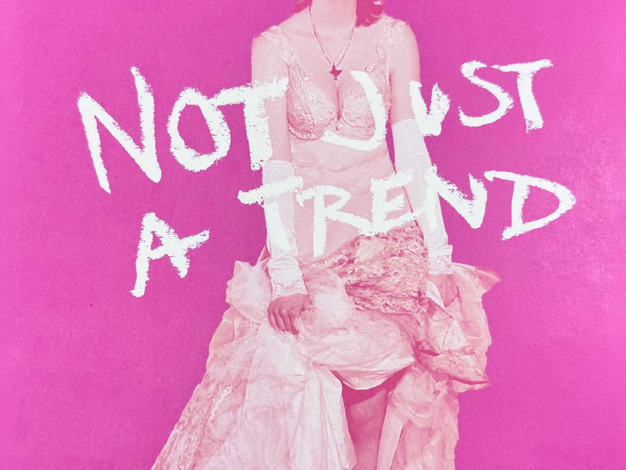 Pink background with a model in a dress and 'Not just a trend' written over the top in white. 