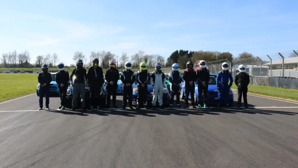 Drivers stood with helmets on in front of care