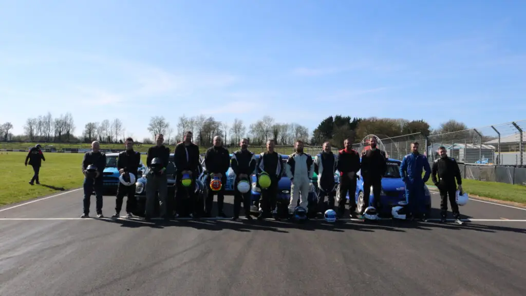 drivers stood with helmets off on track