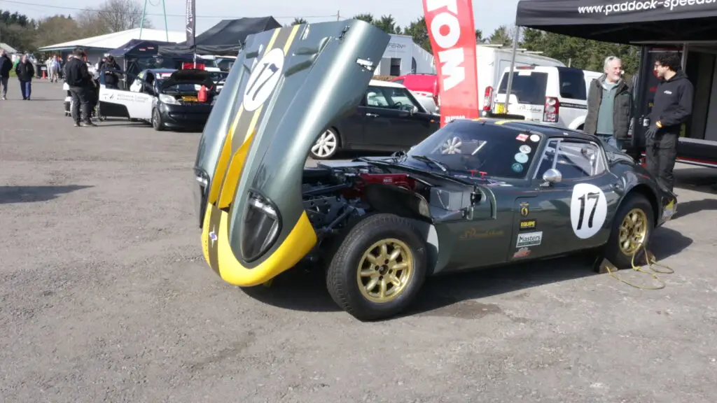 A race car with its bonnet open to explore the car.