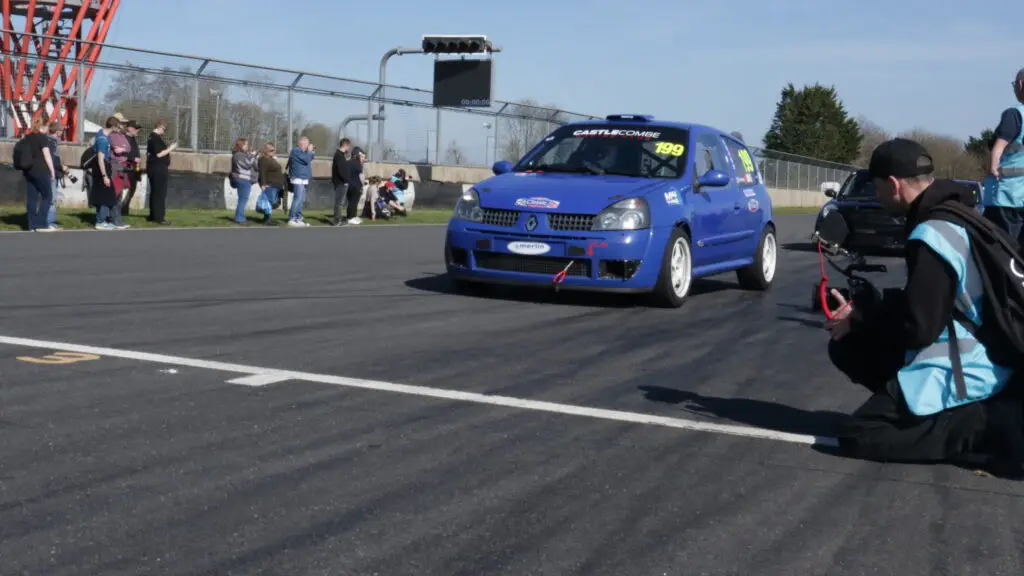 A blue race car going across the line for another lap.