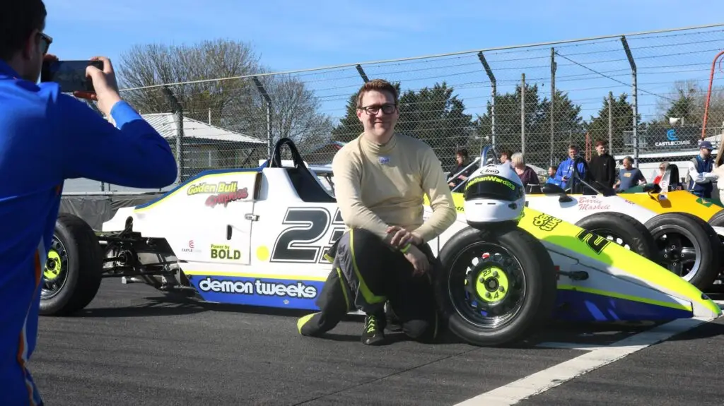 Man posing in front of a car
