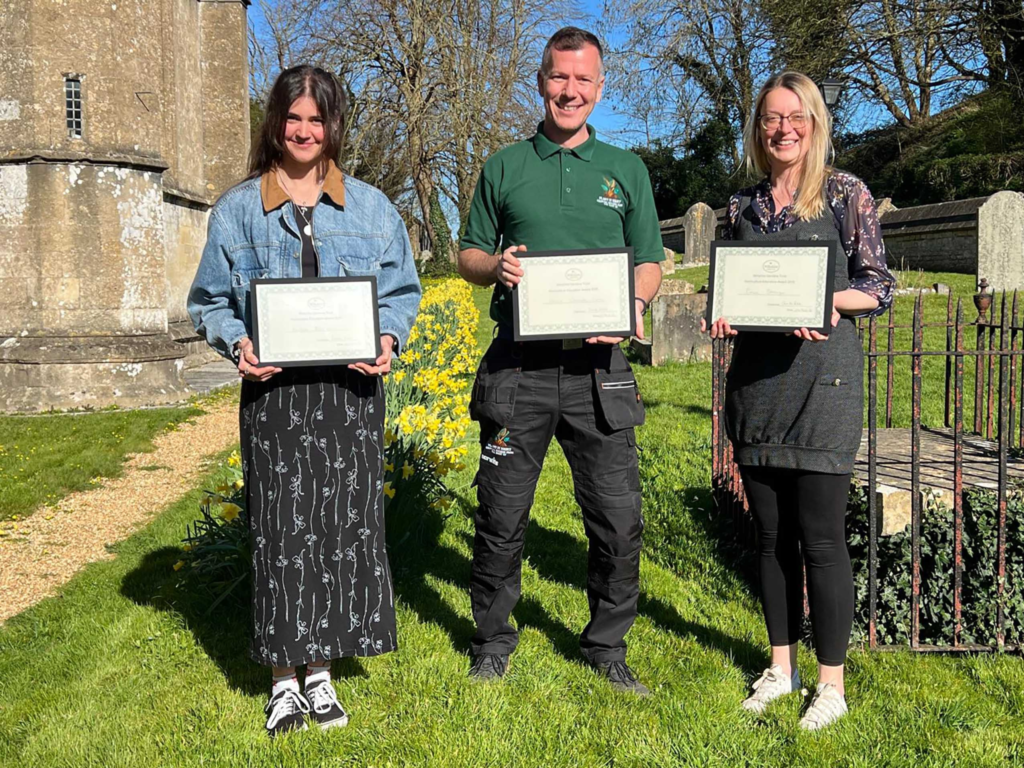 Three students holding certificates