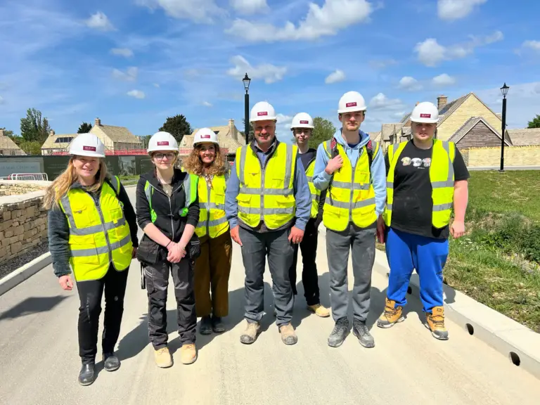 Construction students with hard hats and high vis with Bewley Homes staff members on a housing development