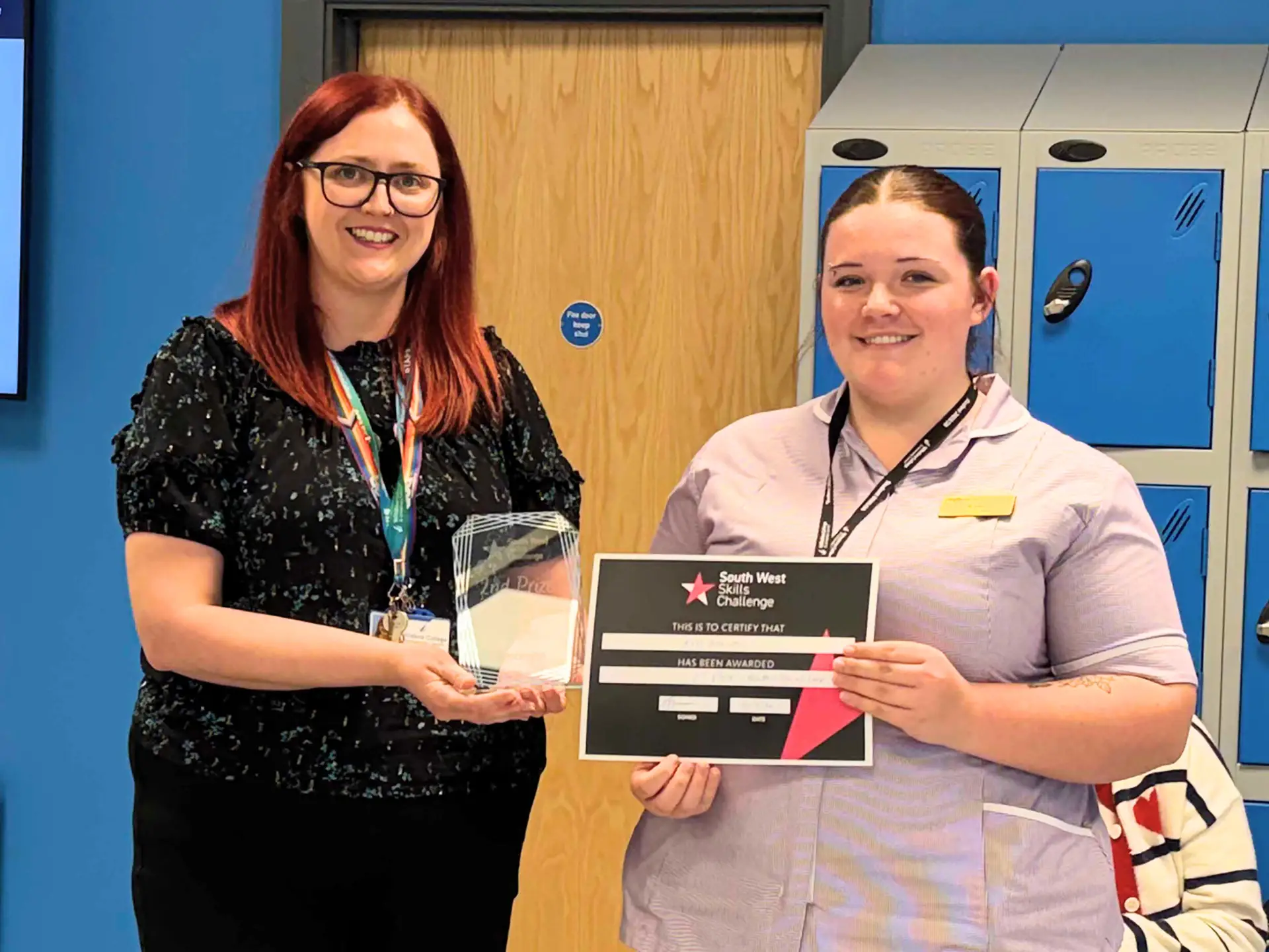 Student with her certificate and a lecturer holding a glass award