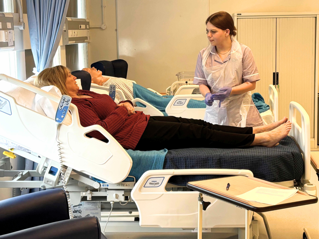 Healthcare student at a bedside of a patient 