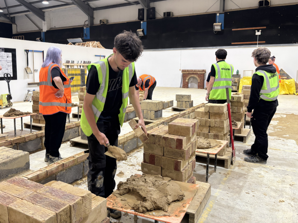 Bricklaying students finish up the year in a competition to build a line faster than their lecturers.