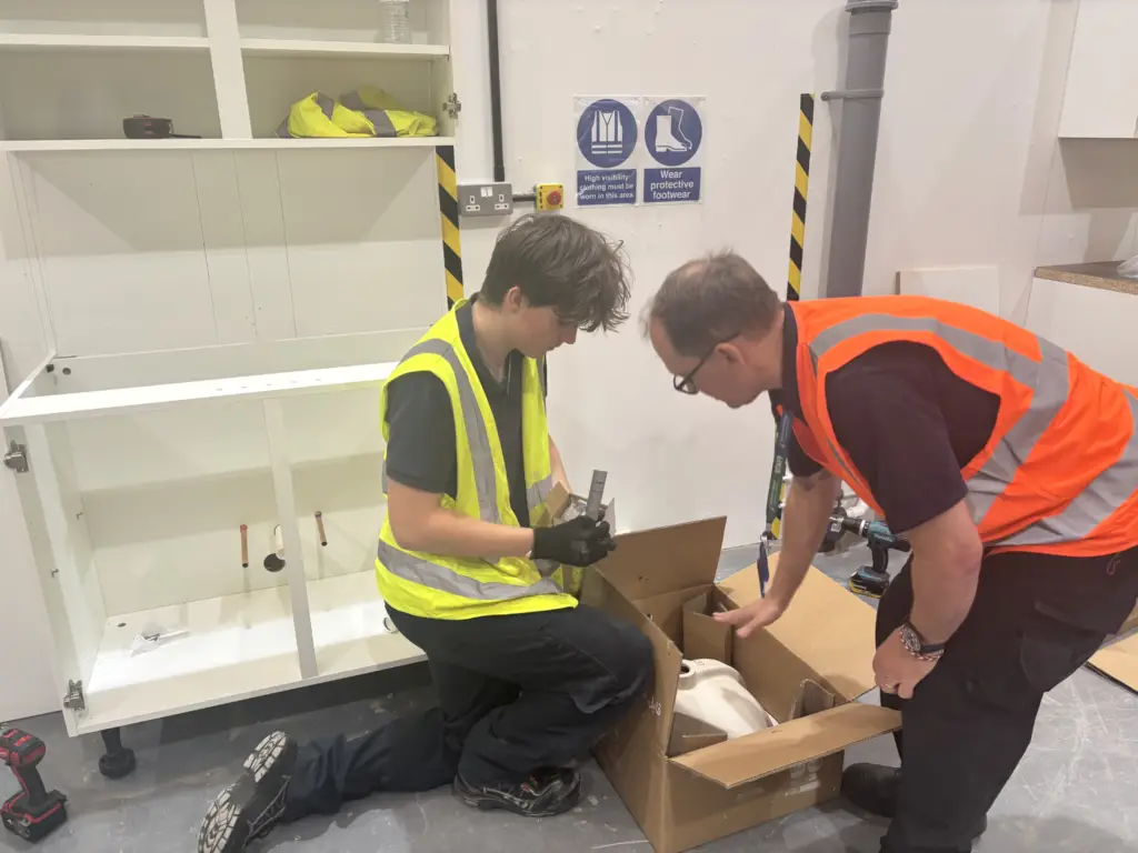 Lecturers supporting students as they work on their utility for the College's Construction Skills Competition