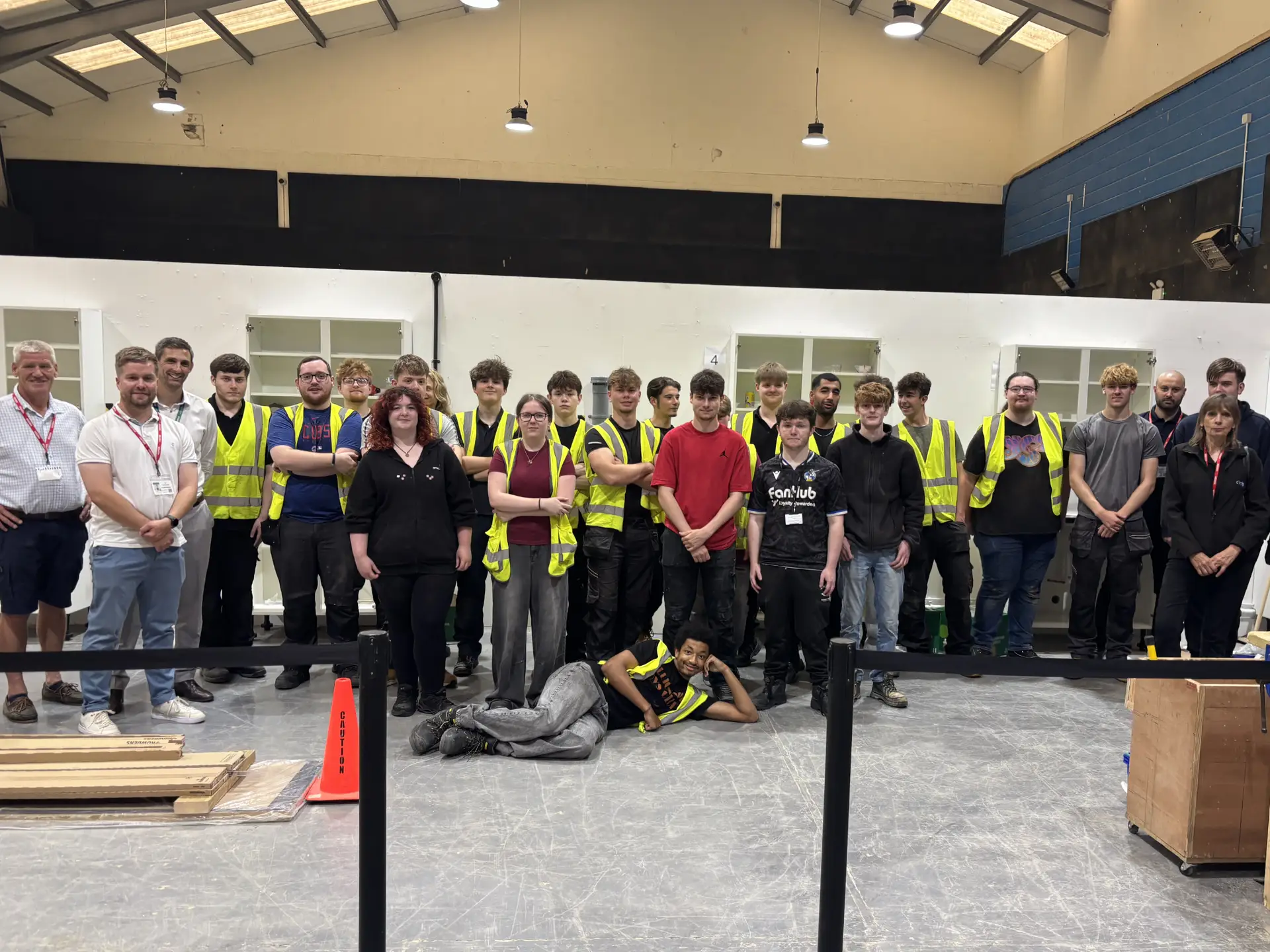 Group picture of construction students, college staff and industry partners and employers inside the College's construction workshop.