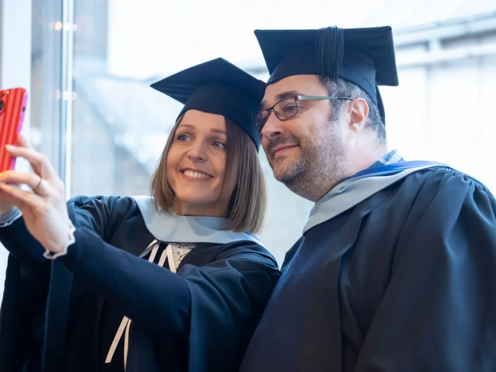 two graduands pose for a photos 
