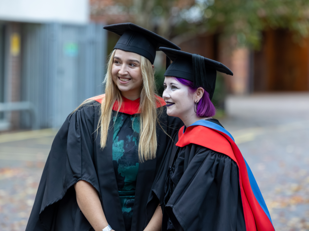 Two graduands talking to others out of shot. 