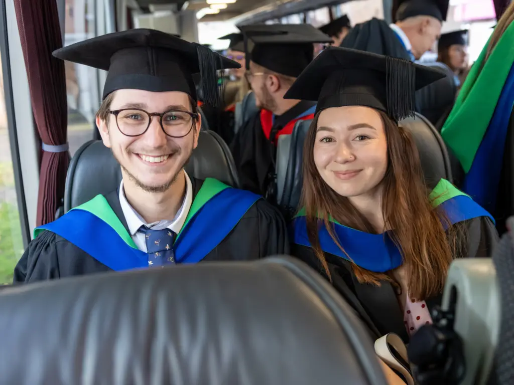 Two graduands on the coach ready to go to the cathedral 