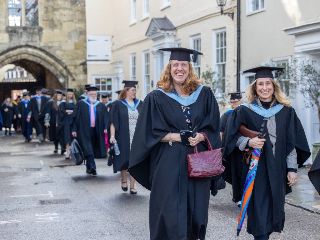 Graduands walking in unison through the cathedral grounds 