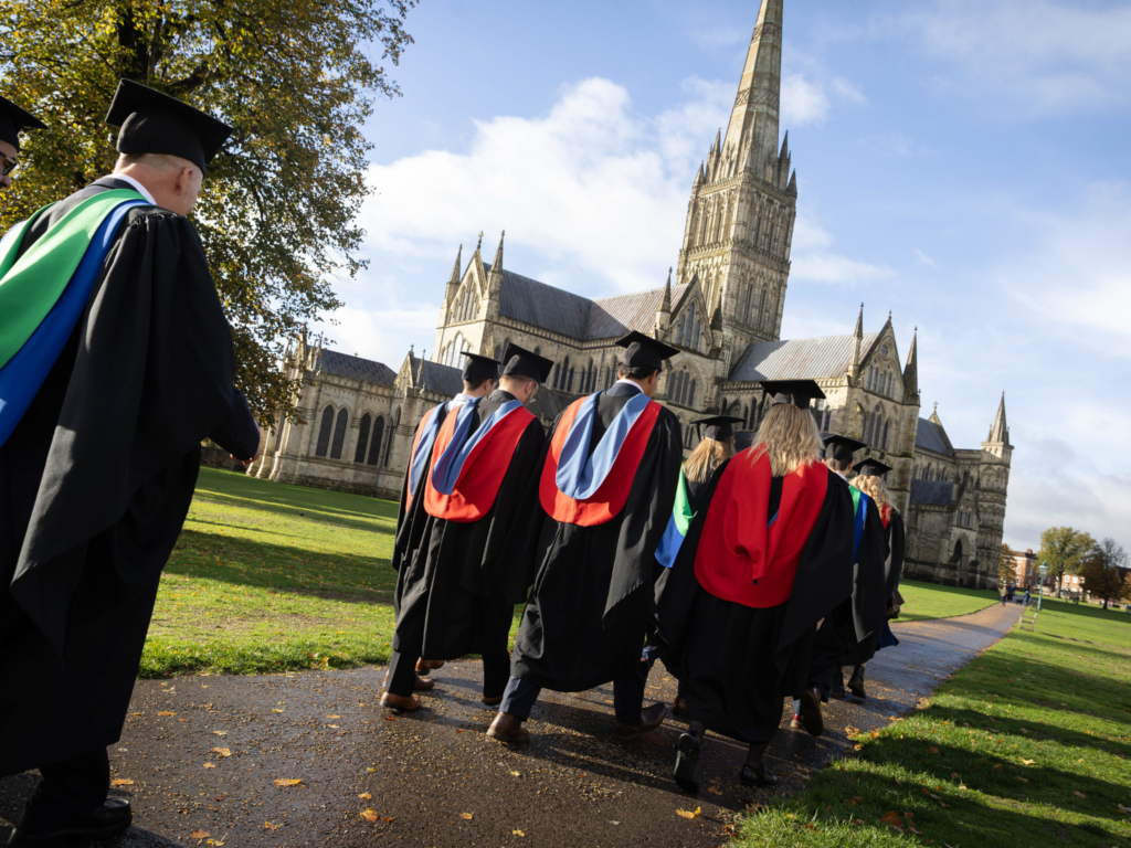 Graduands walk towards Salisbury Cathedral 
