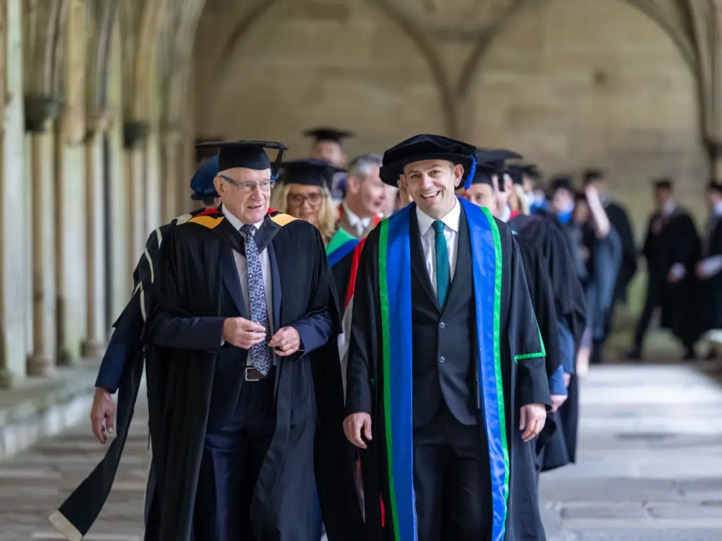 Principal and CEO Iain Hatt with MBE Paddy Bradley, walking ahead of the stage party and graduands through the cathedral grounds 