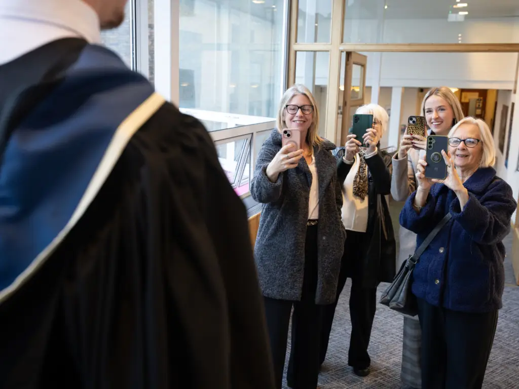 Family taking photos of a graduand out of shot - proud family moment